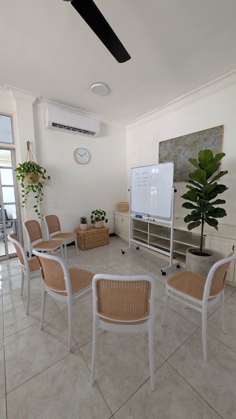 A calm group therapy room with chairs arranged in a circle around a whiteboard