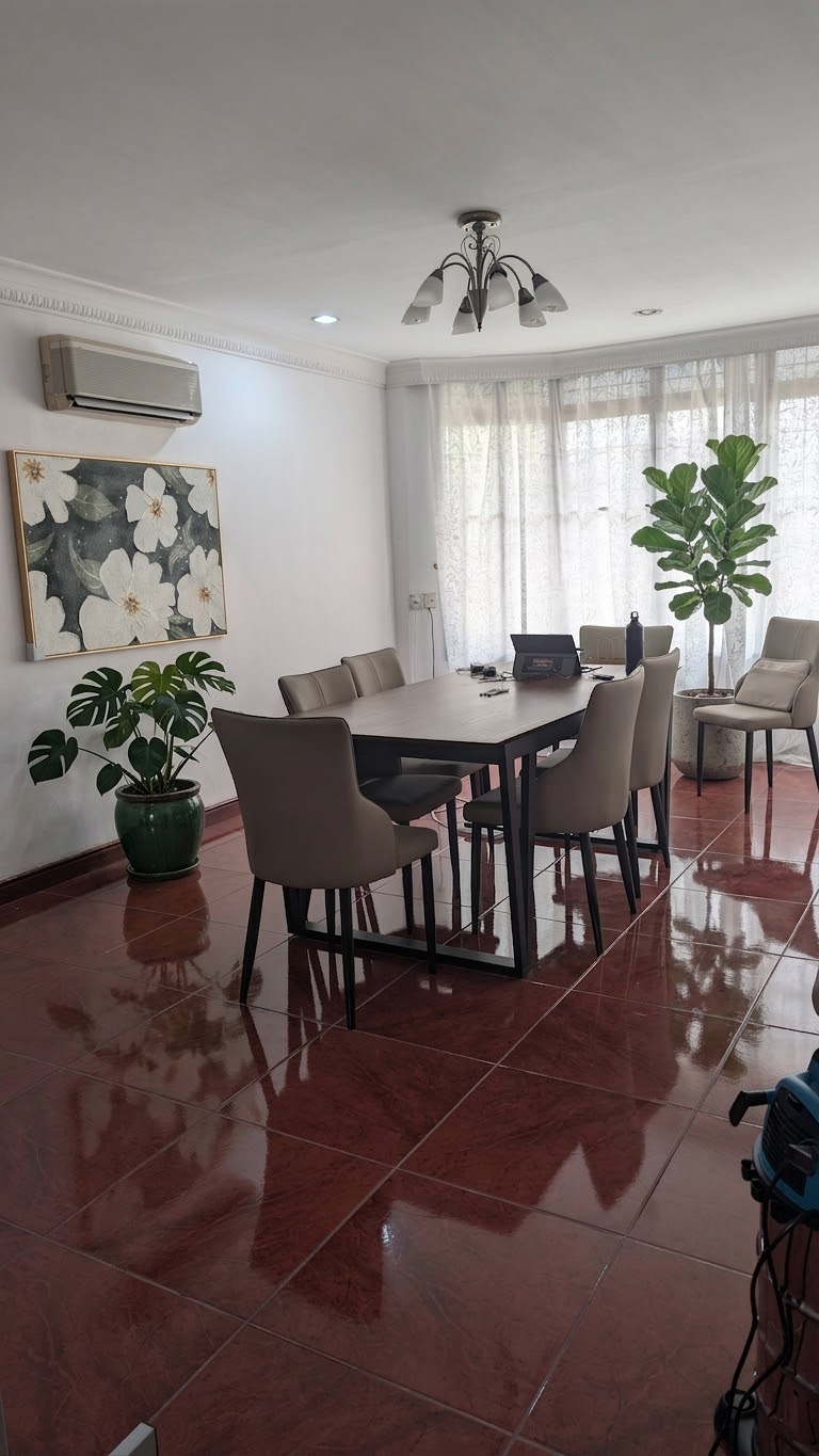 A bright dining hall with a large table, comfortable chairs and indoor plants